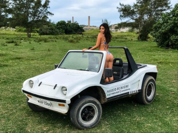 Turista em biquíni em um bugre branco em arraial de capa
