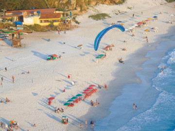 Vista em altura da praia do arraial do cabo enquanto eles estão preparados para decolar com paramotor