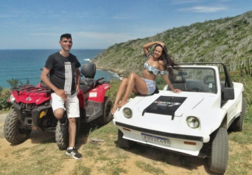 Buggy branco e quadriciclo vermelho com um casal apaixonado olhando a vista alta da praia de Arraial do Cabo