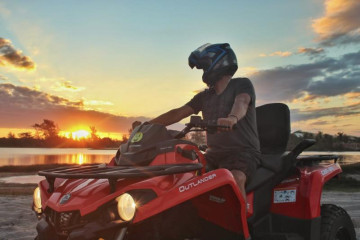 Menino curtindo um passeio de quadriciclo ao pôr do sol em Arraial do Cabo