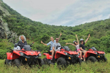 Três amigos que alugaram um quadriciclo por pessoa tiram fotos muito felizes em um morro misturando natureza e aventura