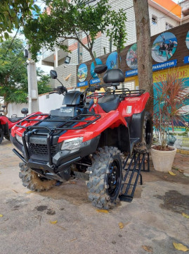 Quadriciclo de aluguel vermelho estacionado em frente a agência de turismo de Arraialferias, passeios e excursões em Arraial do Cabo