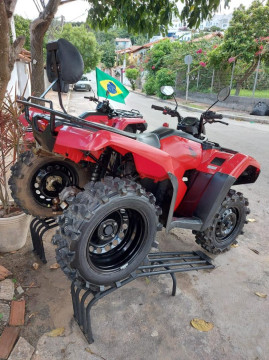 Quadriciclo de aluguel vermelho com as rodas traseiras levantadas em uma calçada em Arraial do Cabo