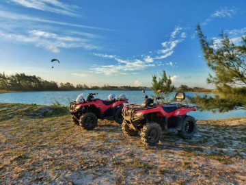 Dois quadriciclos vermelhos para alugar estacionados em uma praia em Arraial do Cabo