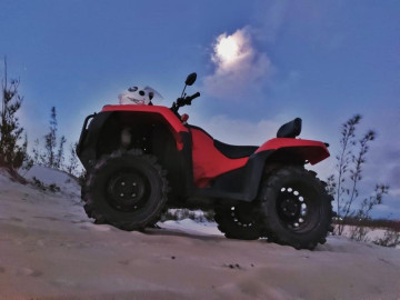 Quadriciclo vermelho para alugar estacionado na praia ao pôr do sol em Arraial do Cabo