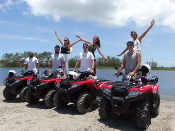 Grupo de turistas que alugou quadriciclos em Arraial Ferias tira fotos em uma praia de Arraial do Cabo em suas férias